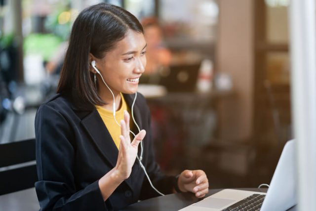 A girl is waving her hand while appearing in a telephonic interview