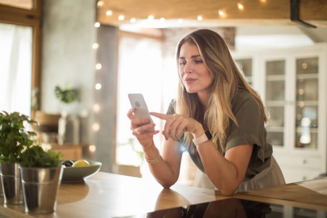 A young lady checking her recently bought refurbished phone 