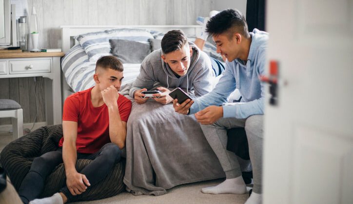 Three young boys searching for the best snapchat alternative in their mobile phones