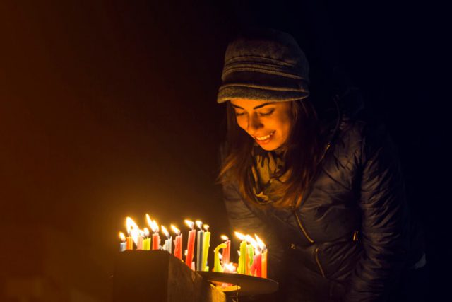 Happy Colombian woman lighting candles outdoors during the Noche de Velitas celebration that takes places on the 7th of December and marks the beginning of Christmas time