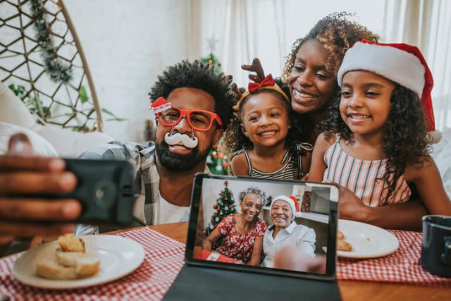 family sharing silly christmas selfies with their family online to celebrate Long-Distance Christmas