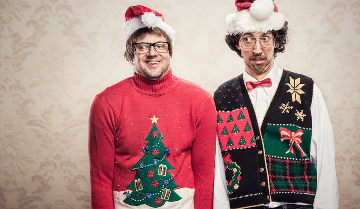 Two goofy looking men in ugly looking Christmas cardigans