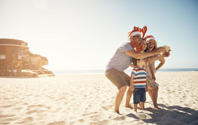 Shot of a family taking a selfie at the beach on Christmas