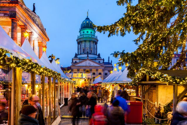 Berlin, Germany - December 2, 2013: View of people making their way through the Christmas market set up in Gendarmenmarkt in Berlin, Germany during twilight