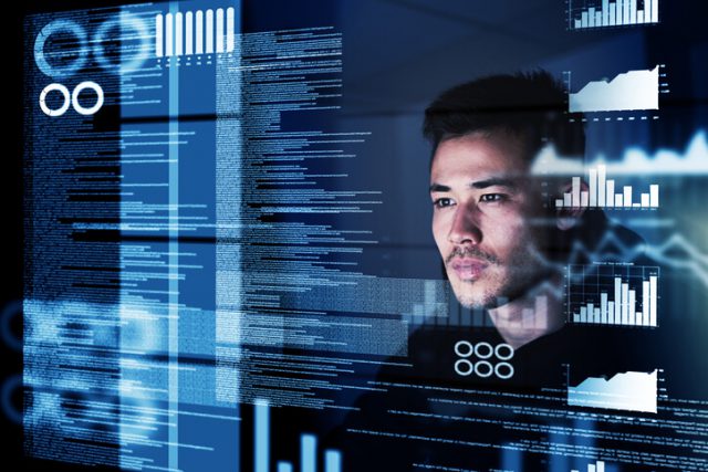 cyber security image showing a focused computer programmer working at his computer late at night showing 