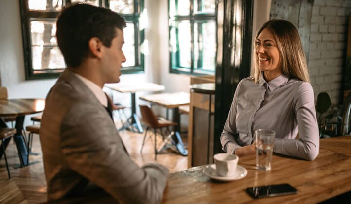 Millennial coworkers in coffee shop after work discussing their work, having a date
