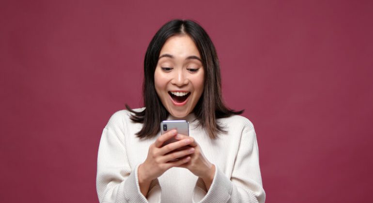 Young asian cheerful woman surprised to find the best phone under 500