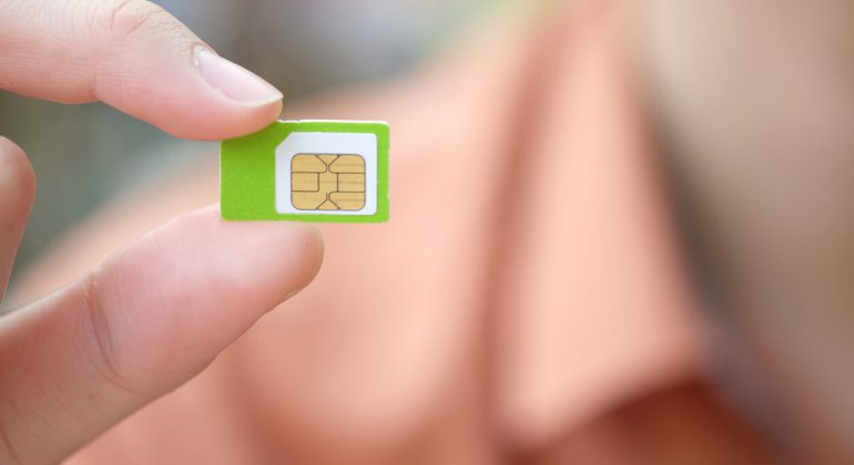 person holding a sim card in his hands with blud background